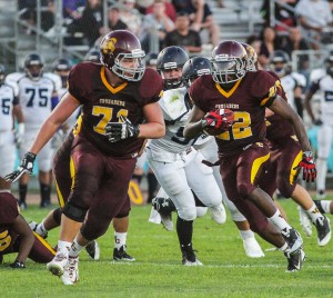  PHOTO BY MIKE ZOETEWEY   Valley Christian sophomore right guard Eric Schoonover provides ample room for senior running back Jonathan Nicholson to pick up some yards in last Friday night's season-opening 50-6 win over Duarte. Nicholson rushed for 146 yards on 16 carries and scored four touchdowns. 