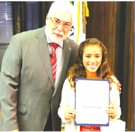 La Mirada Mayor Steve De Ruse presents 7th grade student Madeline Hernandez of St. Paul of the Cross with a certificate of recognition for winning 1st Place in her age group for the annual “Love a Tree” Poster Contest.