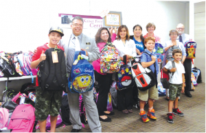  Kaiser Permanente representatives along with Mark Anthony-Ruiz (second from left) giving backpacks to ABCUSD students, Kaiser donated over 170 backpacks. 