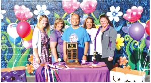 American Cancer Society representatives presented Johnston Elementary School first-grade teacher Dan Calma, center, with a Spirit of Relay award Sept. 23 at the school’s flag ceremony. Photo by Tammye Mcduff.