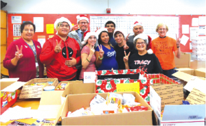 TRACY HELPING TROOPS OVERSEAS: Tracy Students and staff in front of the goodies collected for the troops overseas. Principal Jeff Green, third from left, who's son was stationed in Afghanistan as a helicopter pilot years ago once told his dad "the boxes were a god-send." He joked they could sell a can of Chef-Boy-R Dee for $20 if they wanted. Money donations are also accepted, each box sent cost $17.90. The last possible date to contribute to the gift boxes is December 20th. Donations should go to Tracy ASB or contact 562.926.5566 extension 22201. Photo by Tammye McDuff.